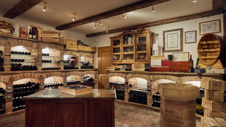 Weinkeller mit Backsteinregalen und Weinflaschen.